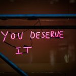 a neon sign that says you deserves it